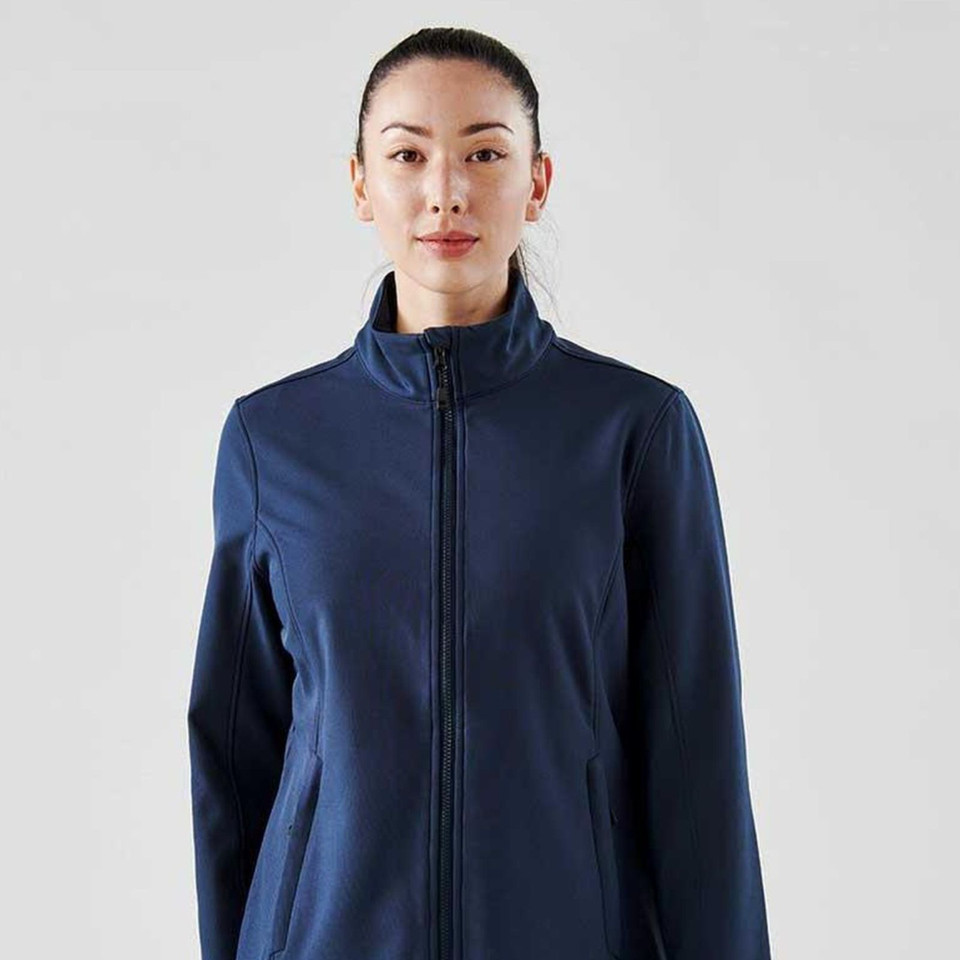 Woman wearing navy blue full-zip softshell jacket with stand collar and clean front panels