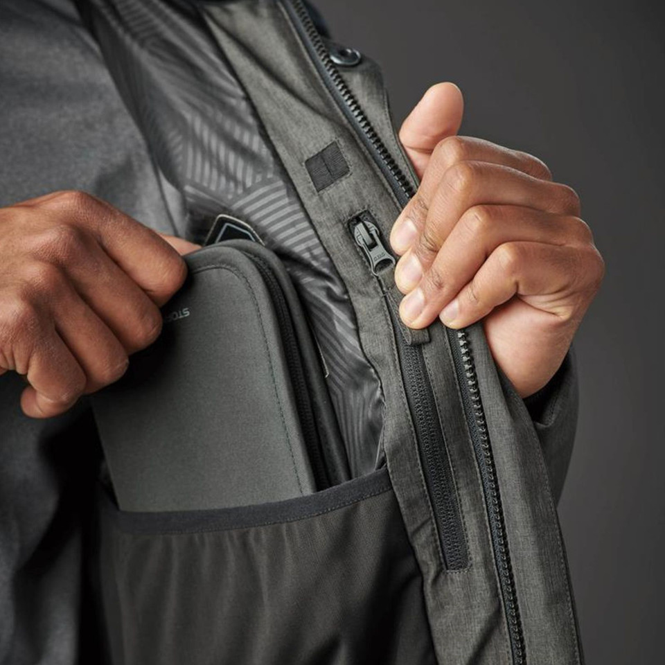Close-up of charcoal insulated parka showing interior zip pocket, dual zip placket, and quilted lining detail