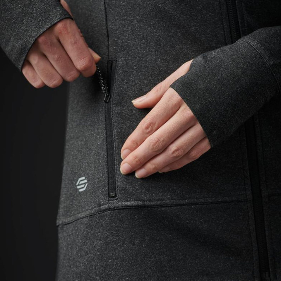 Close-up of charcoal marl jacket zip chest pocket with Stormtech logo detail on women's moisture-wicking fleece