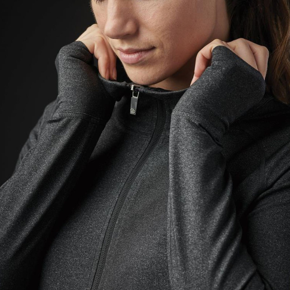 Woman wearing charcoal marl full-zip performance jacket with silver zip pull and thumbhole cuffs