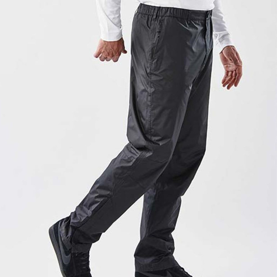 Man walking in charcoal waterproof rain pants with elasticated waist and lightweight shell fabric