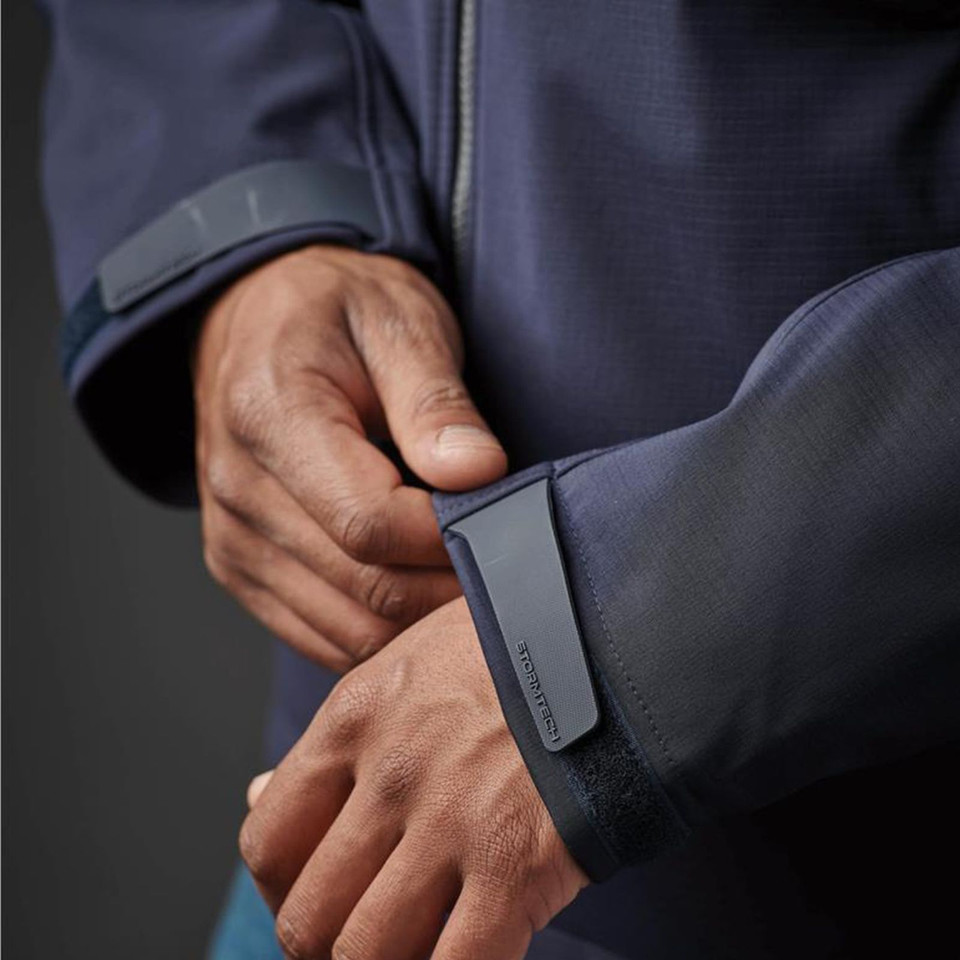 Close-up of navy Stormtech jacket cuff with rubberised branded tab and velcro adjustable wrist closure