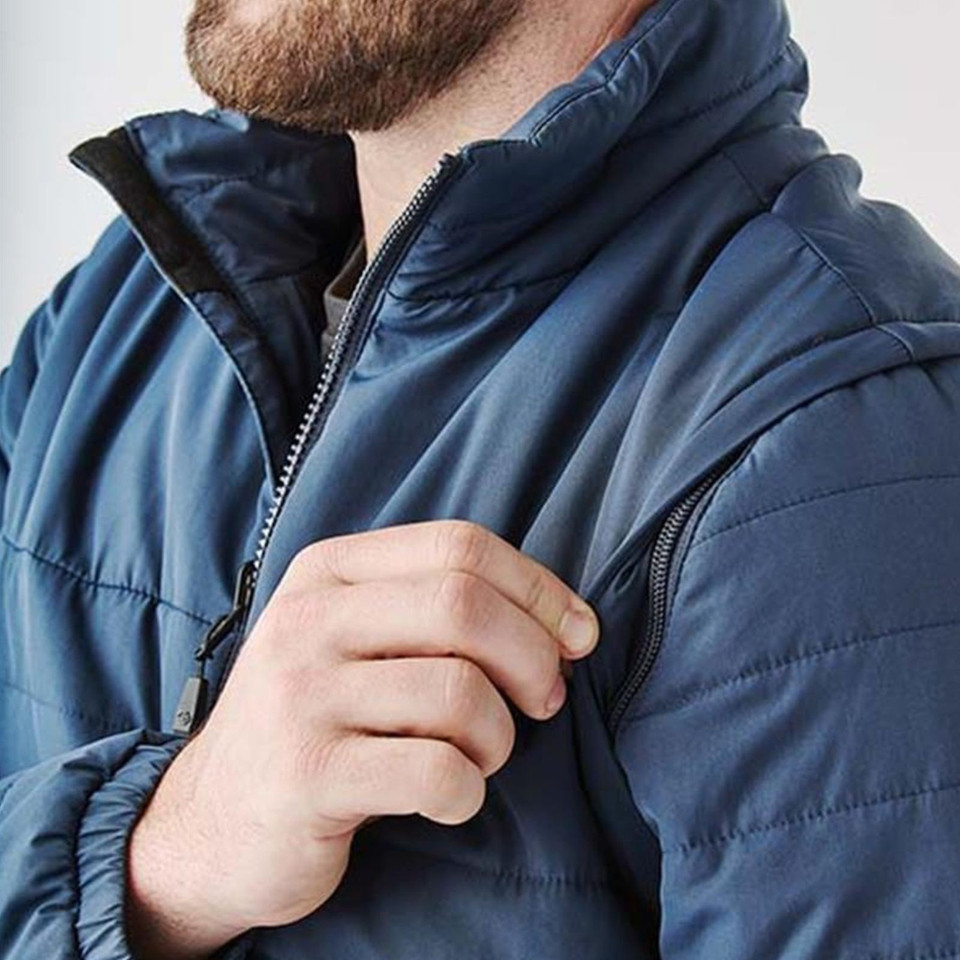 Close-up of steel blue quilted insulated jacket with black contrast zip and chest zip pocket detail on male model