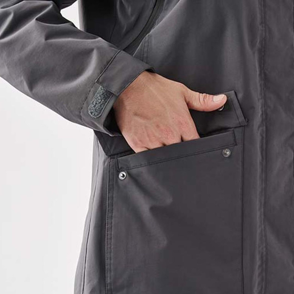 Close-up of charcoal waterproof jacket showing snap-detail side pocket with hand inserting