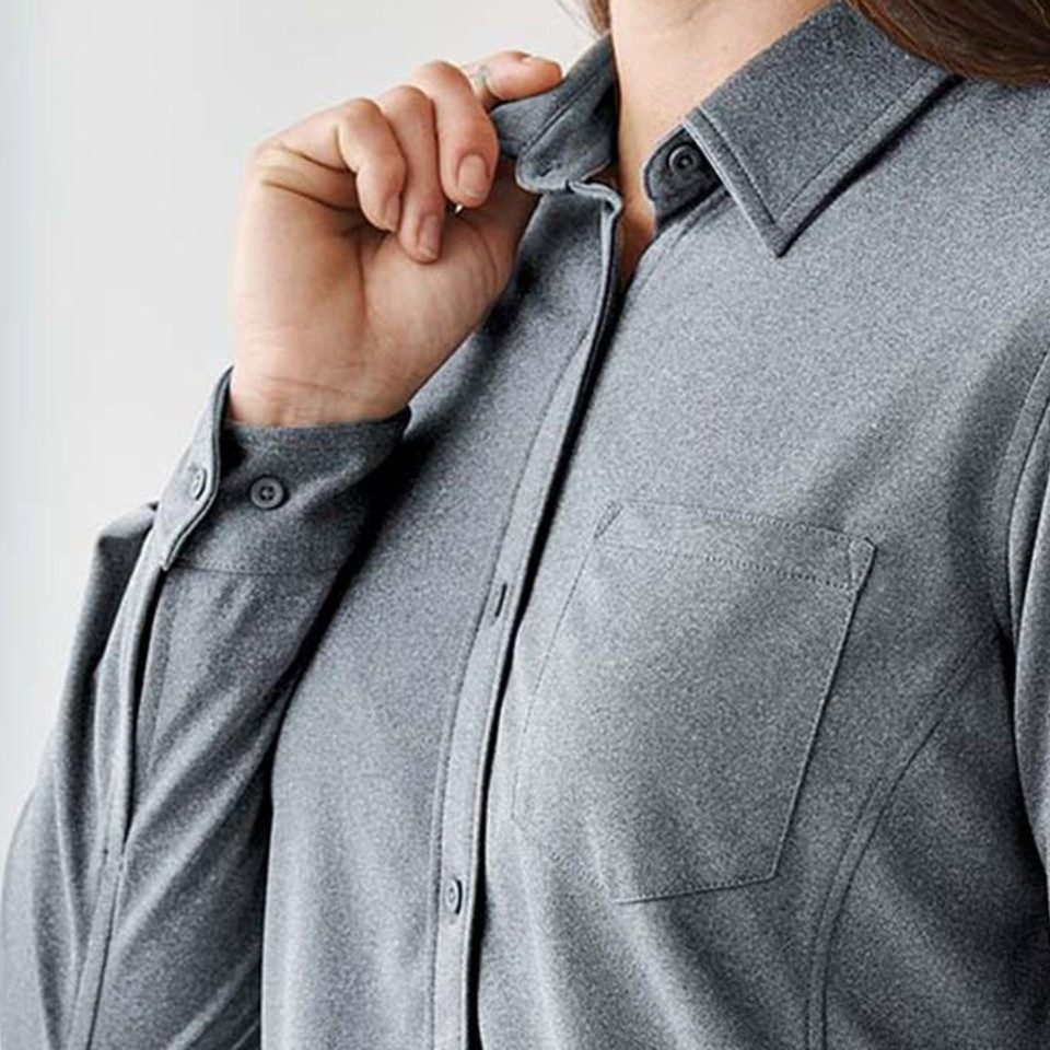Woman wearing charcoal grey long sleeve performance shirt with point collar, button front, and chest pocket