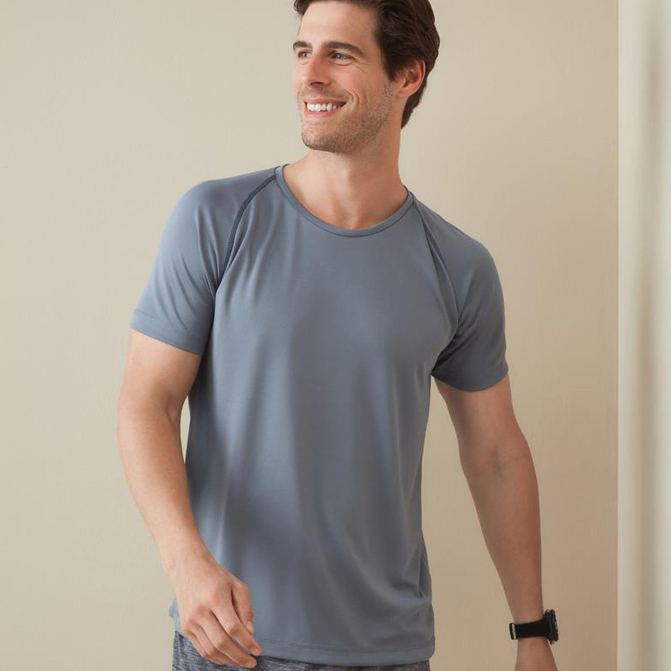 Man wearing a slate blue raglan short sleeve crew neck active tee with smooth performance fabric panels