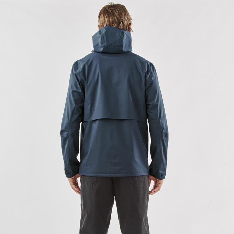 Rear view of man wearing slate blue technical shell jacket with structured hood and back storm panel