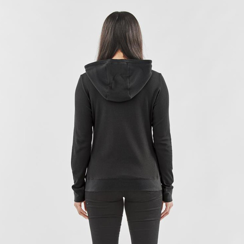Rear view of woman wearing black recycled waffle-texture zip hoodie with fitted hood and ribbed cuffs