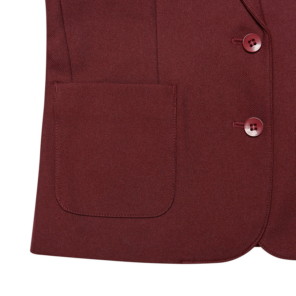 Close-up of burgundy girls school blazer showing patch pocket and tonal buttons on twill fabric