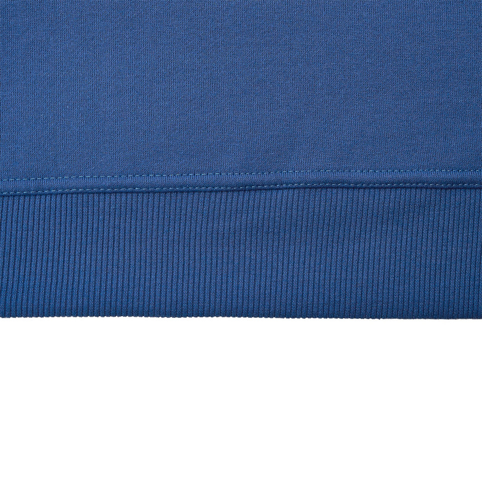 Close-up of royal blue sweatshirt hem showing ribbed waistband and clean flatlock stitching detail