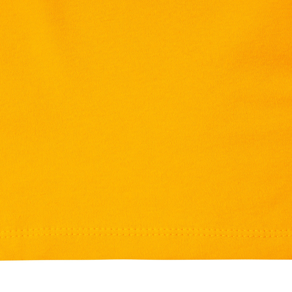 Close-up of gold yellow combed cotton fabric with visible hem stitching detail