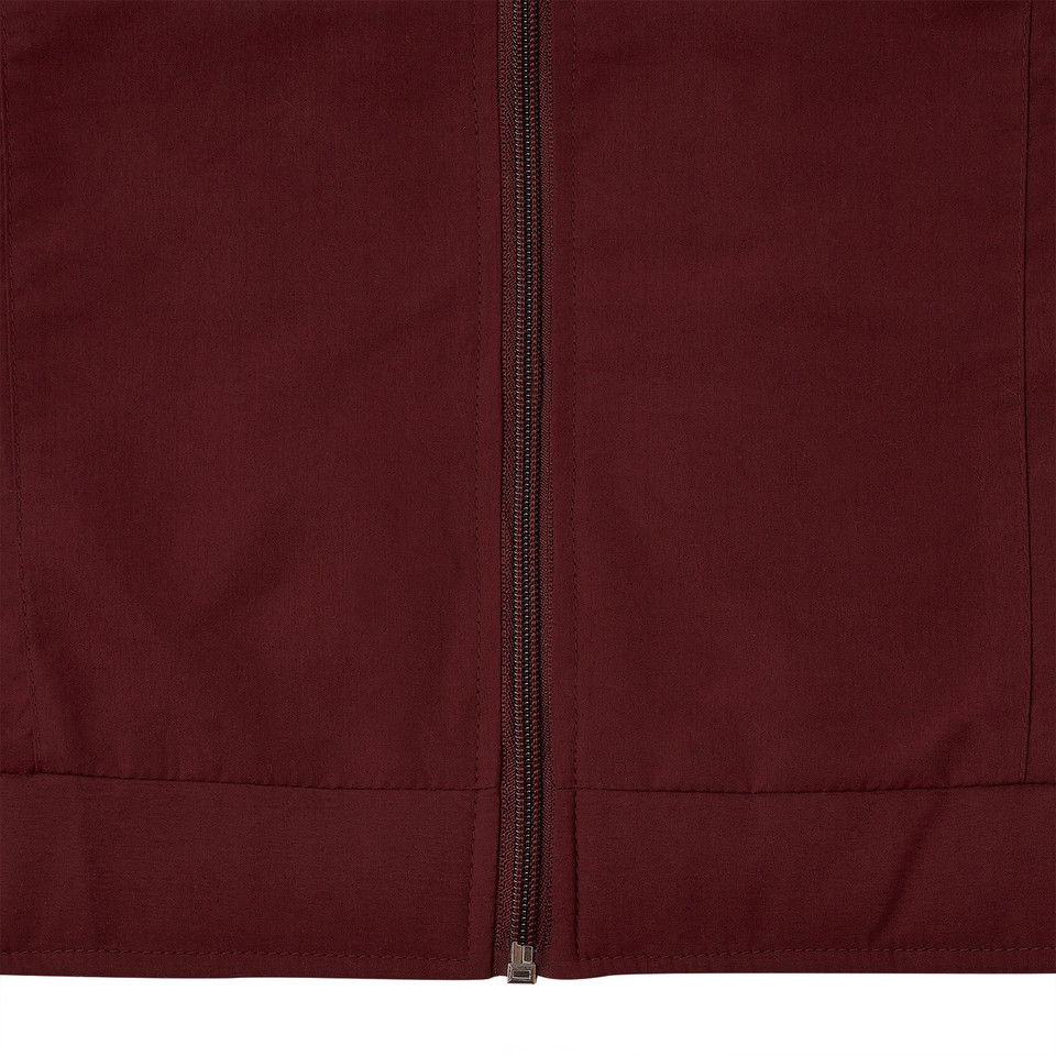 Close-up of burgundy microfibre sports jacket showing tonal zip and lower pocket seam detail