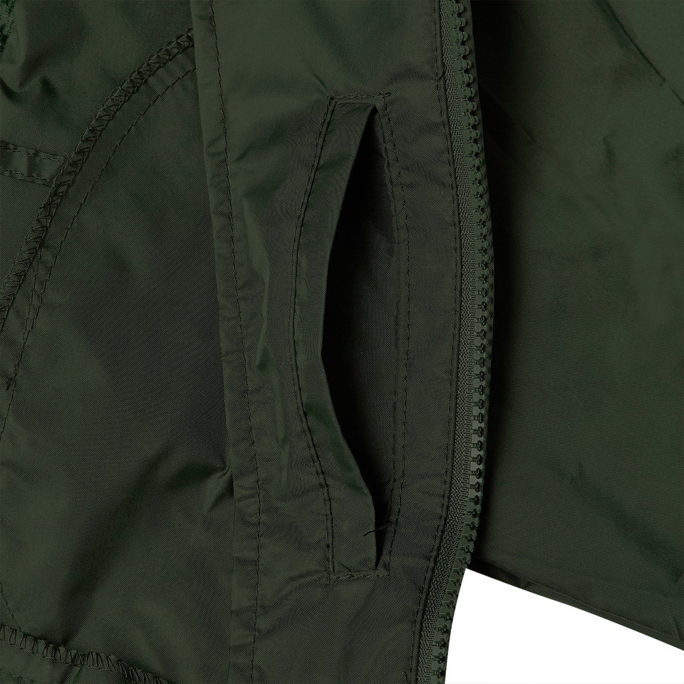 Close-up of forest green jacket showing zip-entry side pocket and nylon shell fabric detail