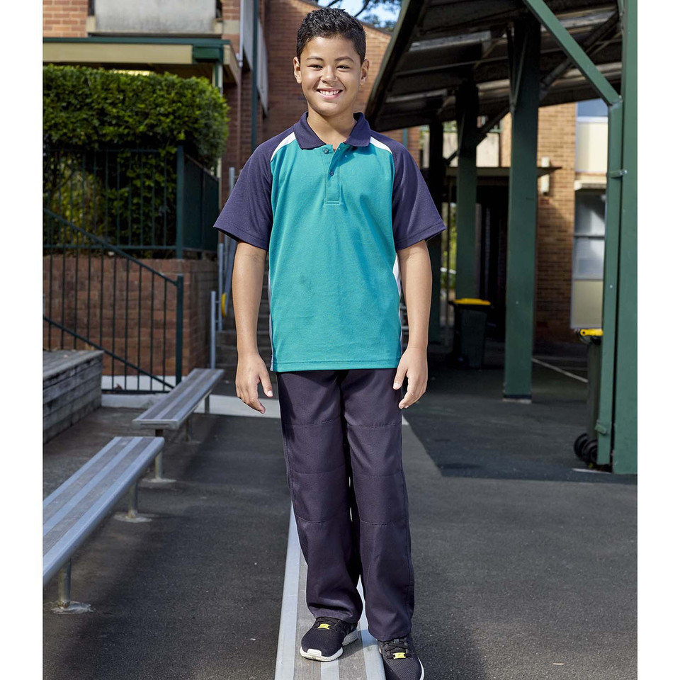 Boy wearing navy gaberdine long pants with double knee panels in a school courtyard setting