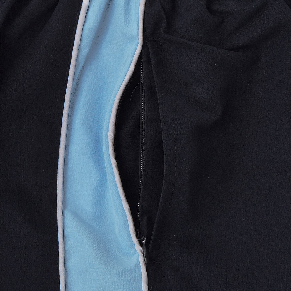 Close-up of navy microfibre sport shorts with sky blue contrast side panel, white piping, and zip pocket detail