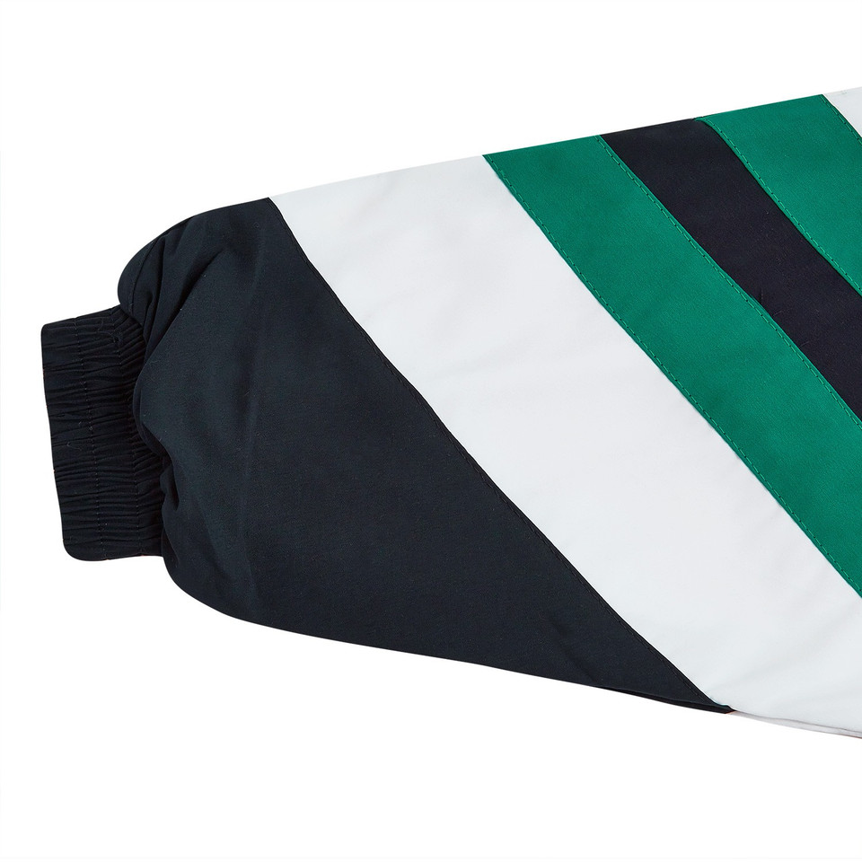 Kids microfibre jacket sleeve detail showing diagonal navy, white and green colour-block panels with ribbed cuff
