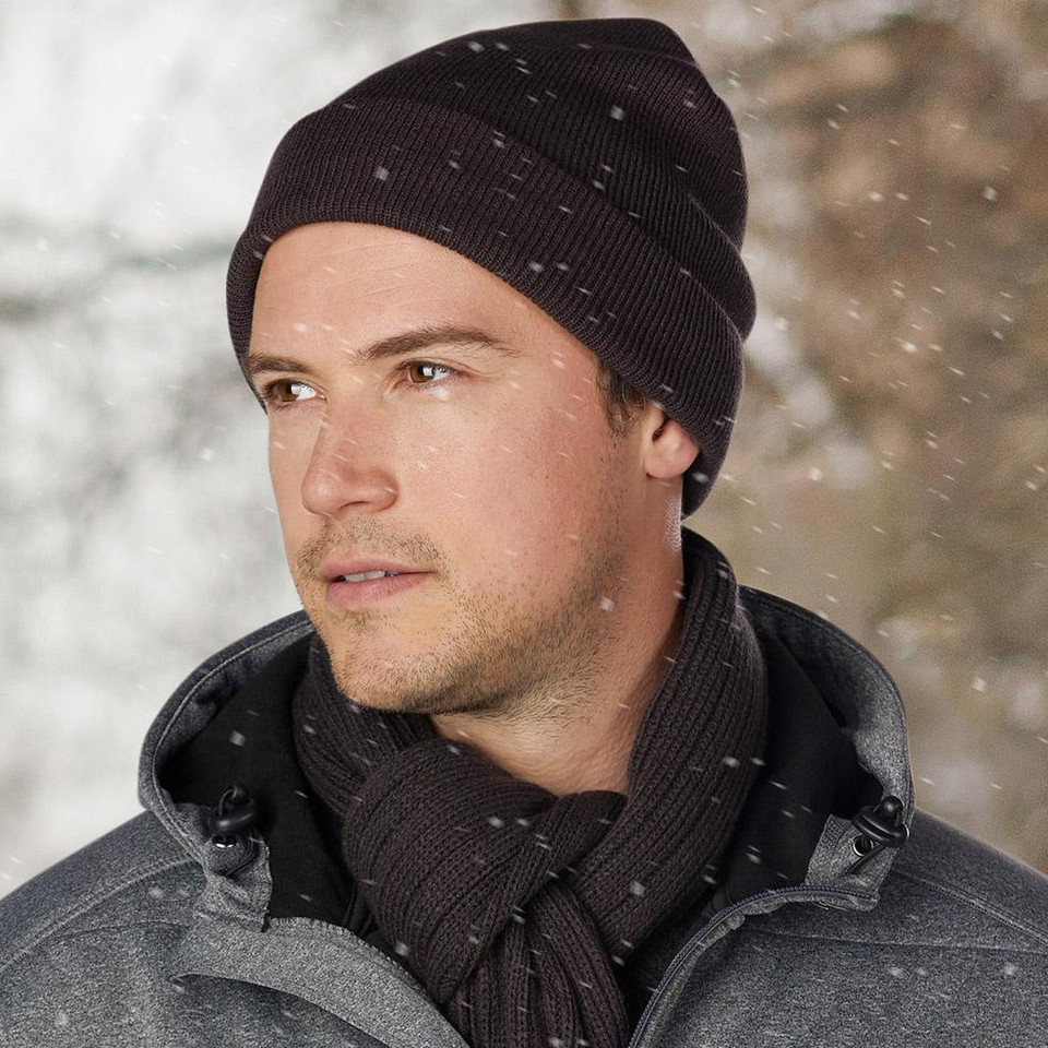 Black ribbed knit beanie with cuff, shown with matching scarf in winter setting