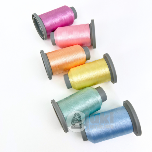 Glide 40 wt Itty Bitty Baby thread bundle with six mini spools in soft pastel colors including baby blue, lemon yellow, periwinkle, pale green, strawberry pink, and cotton candy.