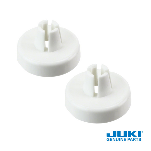 close up of two small thread spool caps for Juki sewing machines