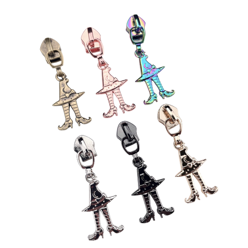 Wild Witches #5 Sewcioath zipper pulls laid down, one of each 6 colors available. Nickel,  gold, rose, antique, rainbow, and gunmetal