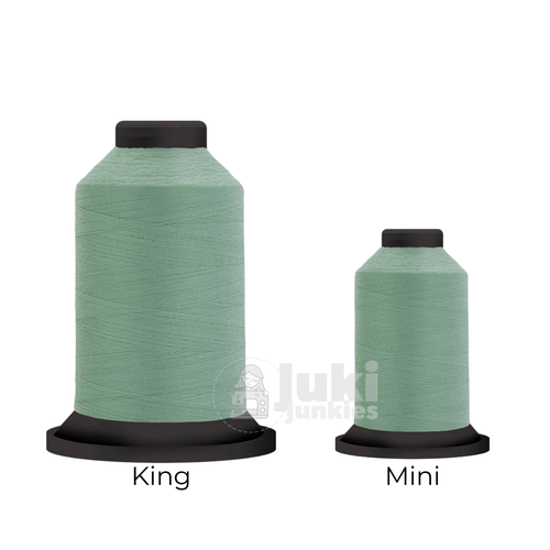 Close-up of two Premo-Soft 50 weight polyester thread spools in Pistachio, showing a soft, matte texture. A large King spool (3,000 yards) and a smaller Mini spool (670 yards) are side by side for size comparison.