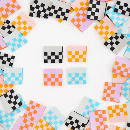 scattered checker print labels in all 4 color ways (black and white, orange and peach, blue and white, orange and lilac)