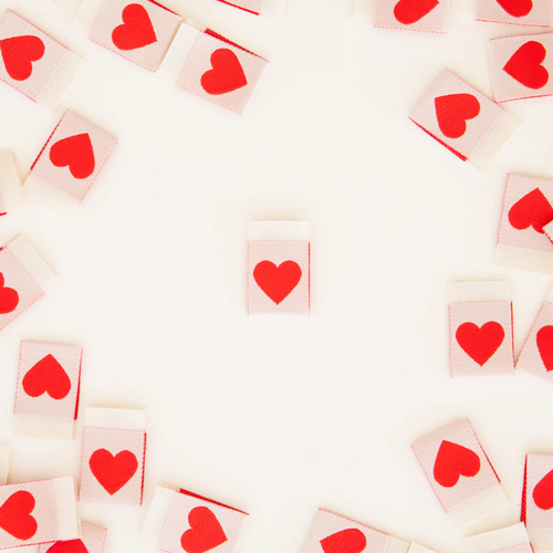 scattered red heart labels on table