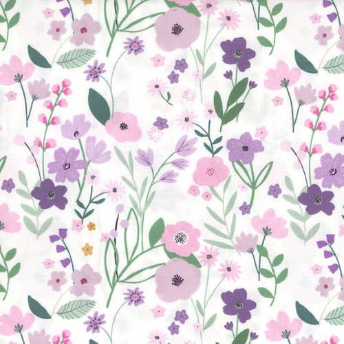 Close up of fabric with a variety of pink and purple flowers on a white background