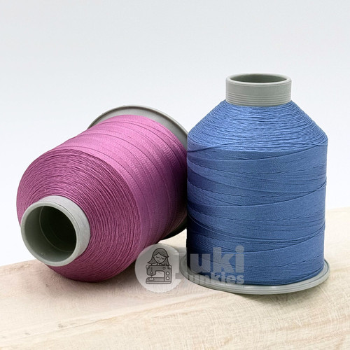Close up of pink and blue thread spools