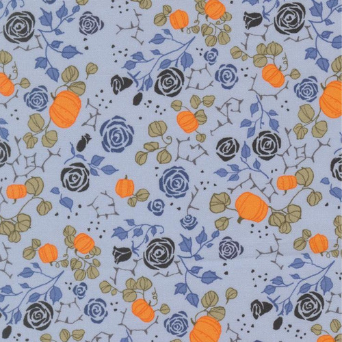 Close up of fabric with black and blue roses and orange pumpkins with green leaves on a light blue background