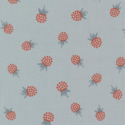 Close up of fabric with red berries with muted leaves on a muted blue background