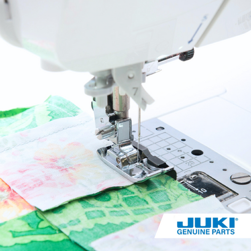 Juki 1/4 inch guide presser foot sewing on green fabric, with fabric edge aligned to the guide for an accurate 1/4 inch seam allowance and stabilized straight stitch