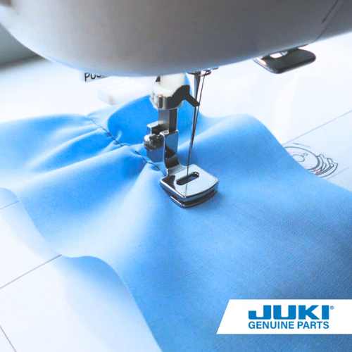 Juki gathering presser foot sewing a single layer of blue fabric, automatically creating soft gathers with adjustable stitch length, tension and foot pressure.