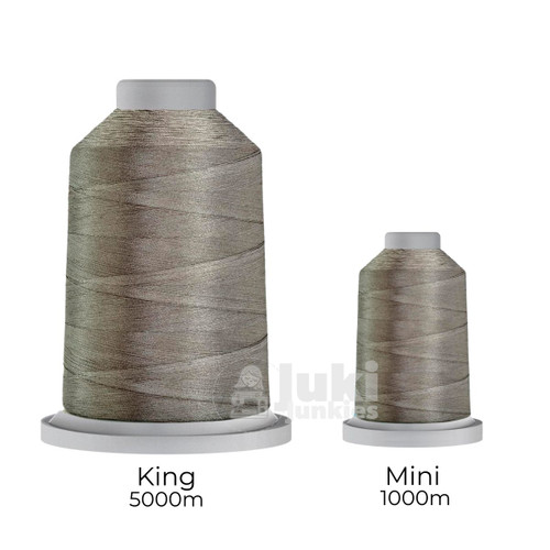 Close-up of two spools of Glide 40 weight polyester thread in Cool Grey 9: a large King spool (5,500 yards) and a smaller Mini spool (1,100 yards), shown side by side for size comparison, with a smooth texture and noticeable sheen.