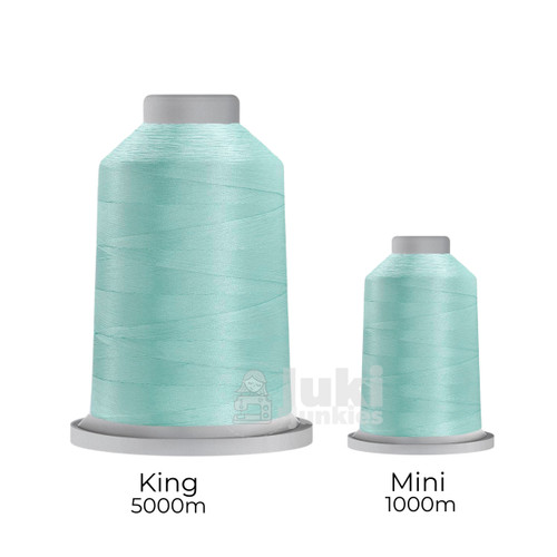 Close-up of two spools of Glide 40 weight polyester thread in Cloud: a large King spool (5,500 yards) and a smaller Mini spool (1,100 yards), shown side by side for size comparison, with a smooth texture and noticeable sheen.