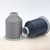 Close up of medium grey and navy colored thread spools 
