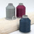 Close up of cool grey, deep pink, and denim blue thread spools