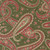 Close up of fabric with an abstract paisley pattern in red and green with a muted green background