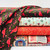 4 bolts of fabric with red cardinals, wreaths, gingerbread men, carols, gold dots, holly, and flowers