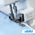Juki taping foot on a serger sewing blue fabric, feeding tape through the front guide while overlocking the edge to reinforce seams such as shoulders with clean, secure stitching.