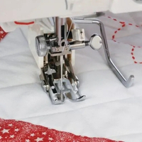 Closeup of the quilting guide bar in action