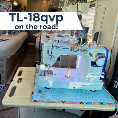 A Juki TL-18QVP sewing machine set up on a foldaway table inside an RV.