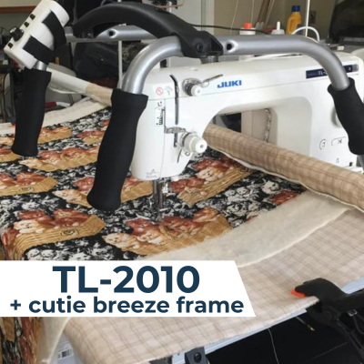 A Juki TL-2010 sewing machine mounted on a Cutie Breeze quilting frame, actively quilting a patterned quilt.