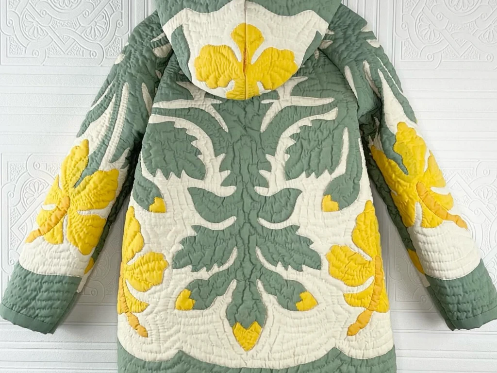 Green and yellow quilted jacket with a floral appliqu\u00e9 design.