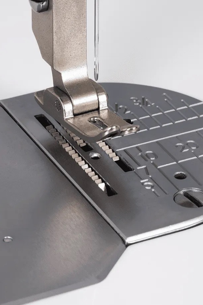Close-up of the Janome HD9 QCP presser foot and needle plate showing the floating function.
