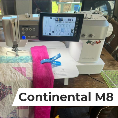 A close up of a quilt being quilted on a Janome Continental M8 sewing machine.