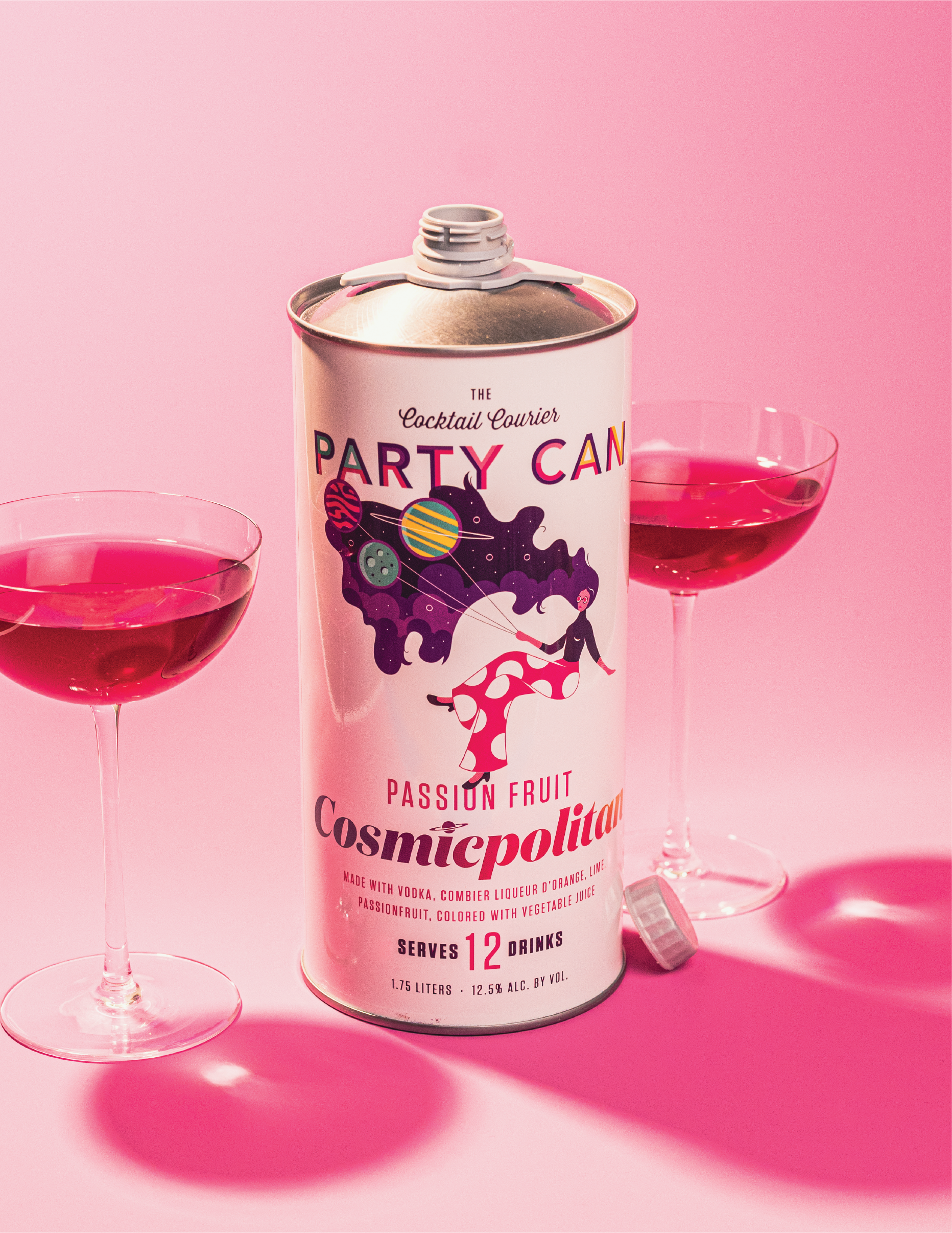 The Party Can Cosmicpolitan Can with the box it comes within and the deep red cocktails in a glass with ice.