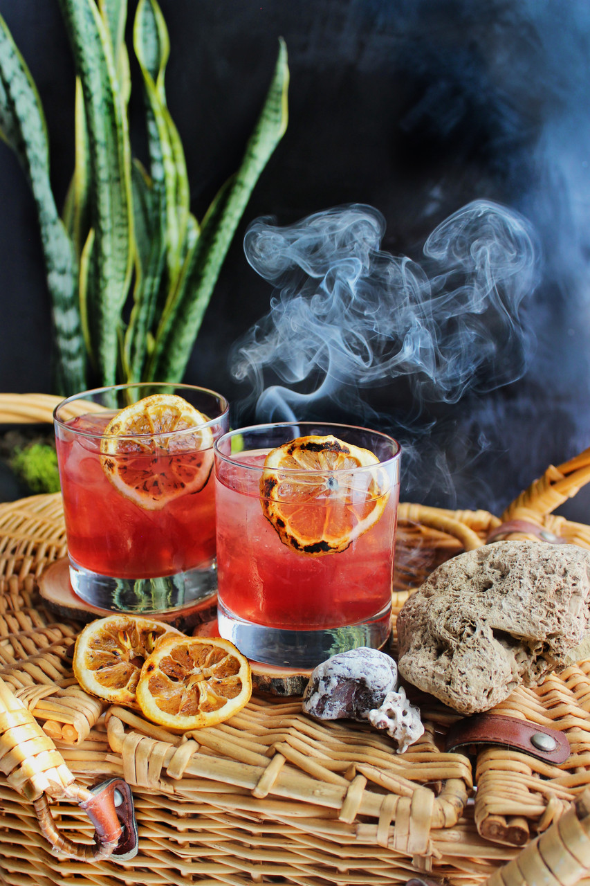 purple hued cocktail with billowing smoke in background