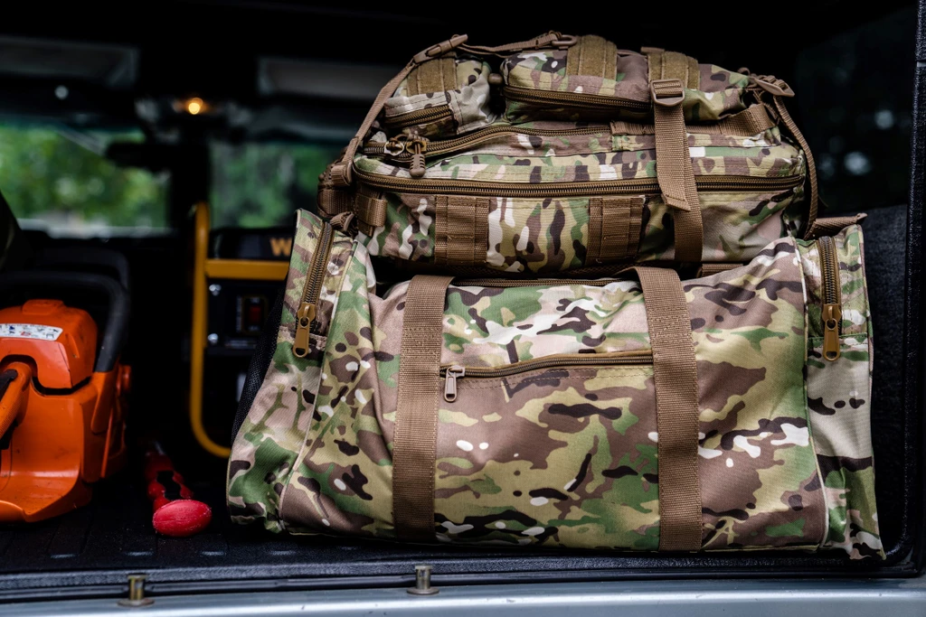 MultiCam® Large Square Duffel with Presidio Backpack on top packed in back of vehicle.