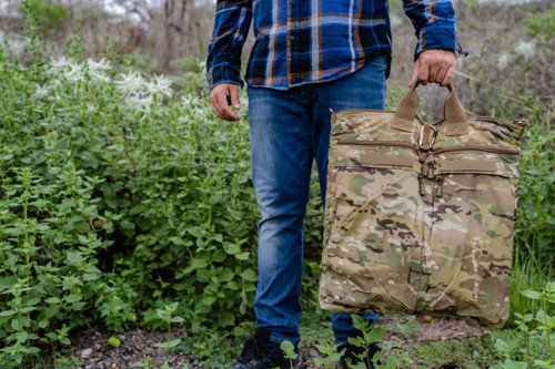 Deluxe Helmet Bag in MultCam® carried by top handle outdoors.